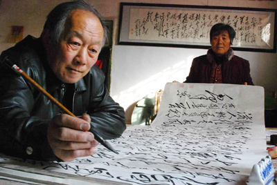 毛体书法家尹天鹏和老伴在欣赏自己的作品