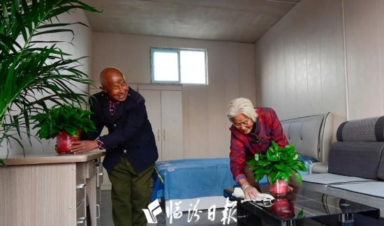 11月19日，霍州市师庄乡冯南垣村76岁的师荣光夫妇搬进灾后重建的新房后，高兴地收拾着家务。 本报记者 李虎威 摄