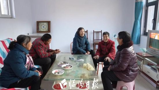 12月9日，在安泽县府城镇凤池村，搬进新家的李冬梅和前来祝贺的邻居们拉家常。 本报记者 赵振宇 摄