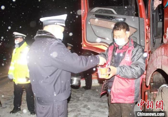 “货车司机雪天被困高速 暖心交警连夜送热水食物